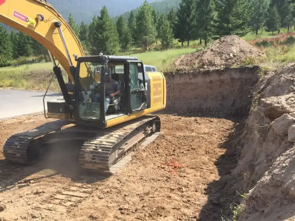 Excavator cutting a foundation on a cleared site