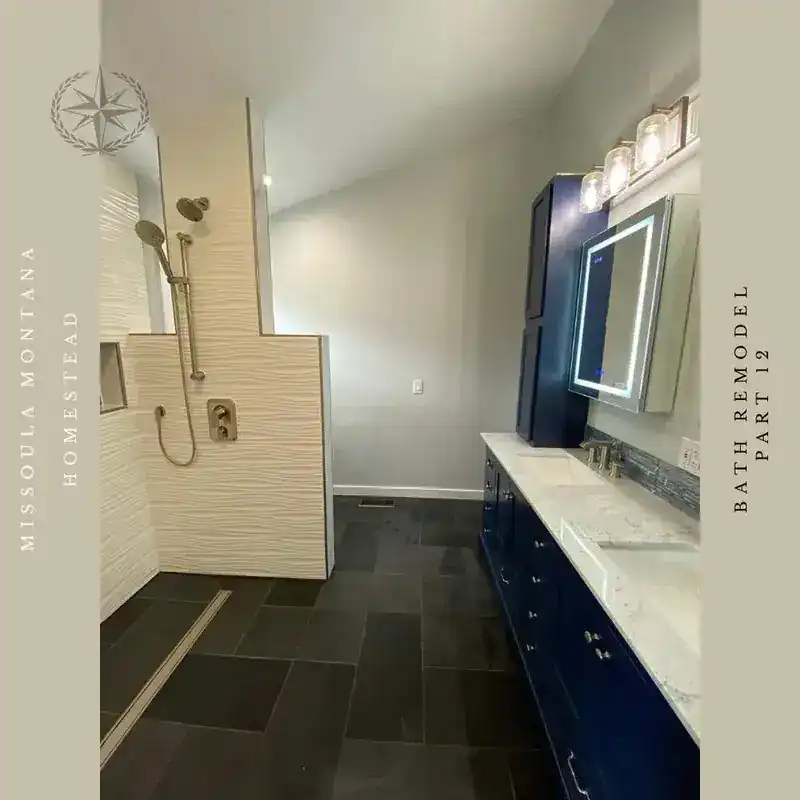 The finished vanity run in navy with stone top and lit mirrors